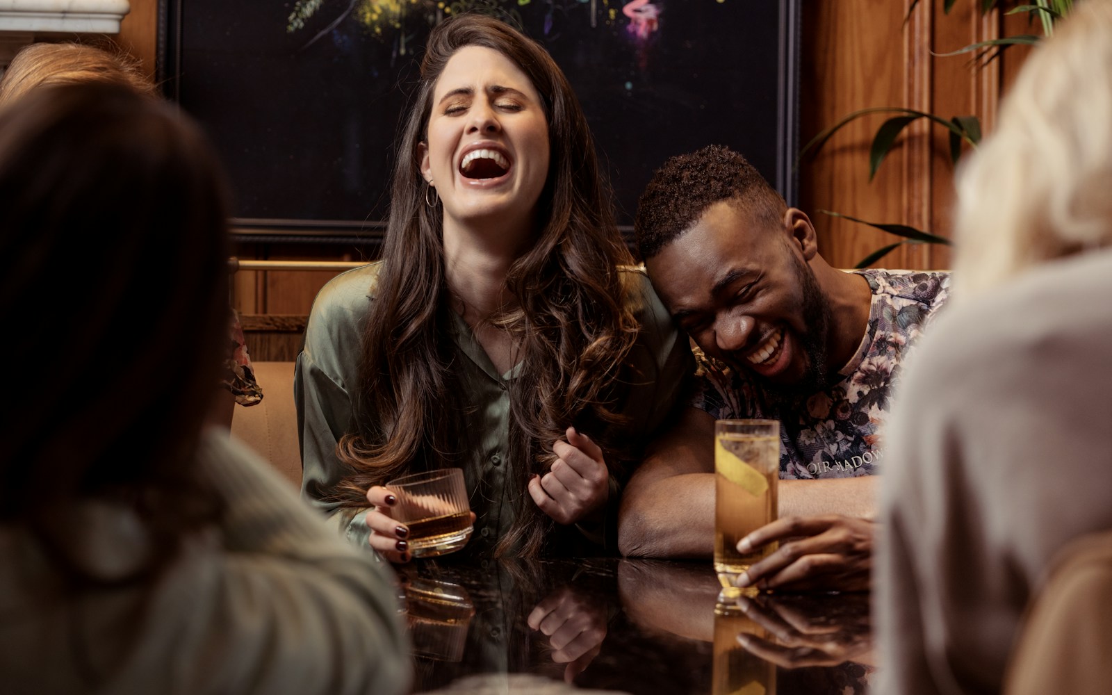 A group of friends laughing together around a table
